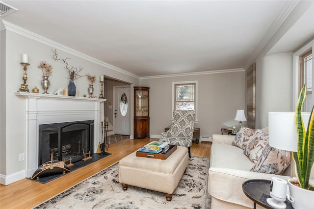 living room featuring ornamental molding, light hardwood / wood-style floors, and baseboard heating