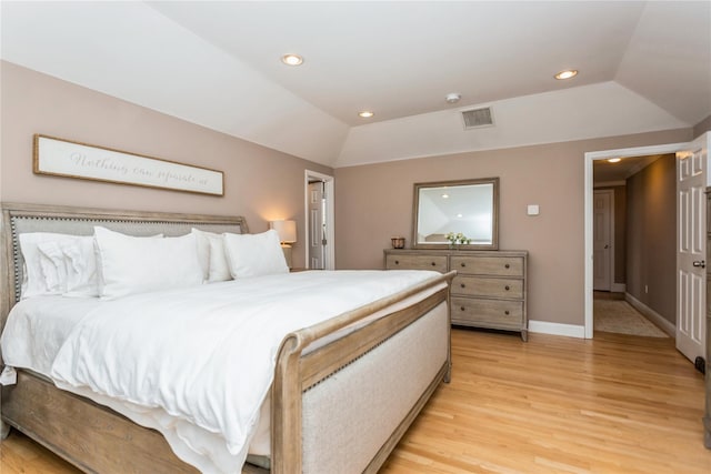 bedroom with vaulted ceiling and light hardwood / wood-style floors