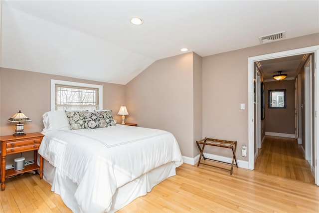 bedroom featuring hardwood / wood-style flooring and lofted ceiling