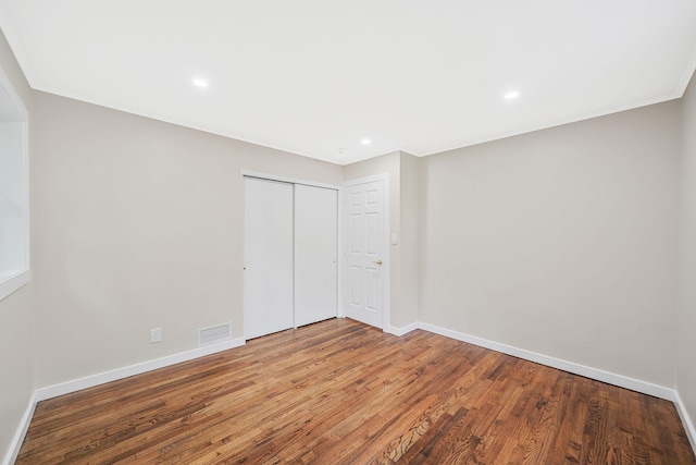 unfurnished bedroom featuring a closet and hardwood / wood-style flooring