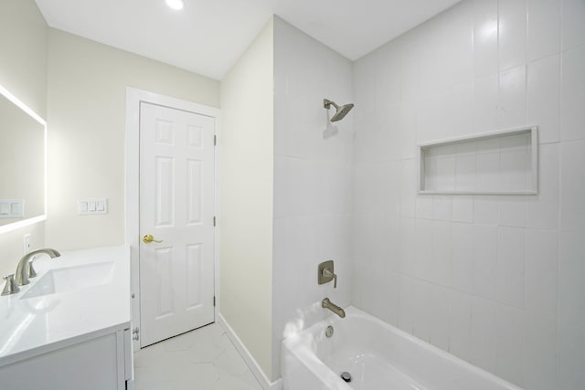 bathroom featuring tiled shower / bath combo and vanity