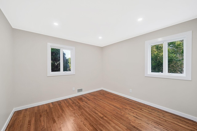 unfurnished room featuring a wealth of natural light and hardwood / wood-style floors