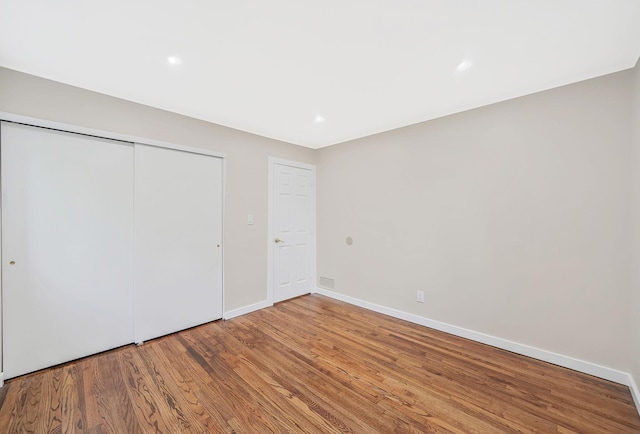 unfurnished bedroom with wood-type flooring and a closet