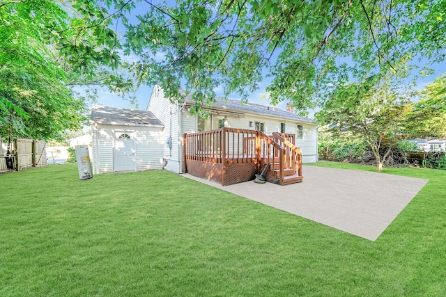 back of house with a lawn, a patio, a deck, and a storage shed