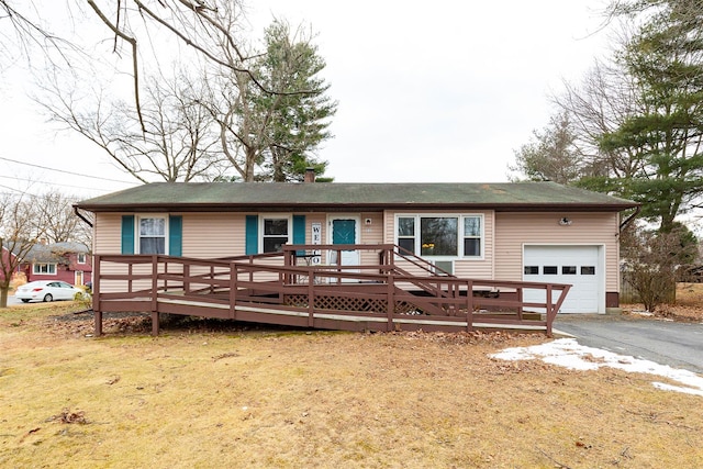 view of front of property with a front yard, a deck, and a garage