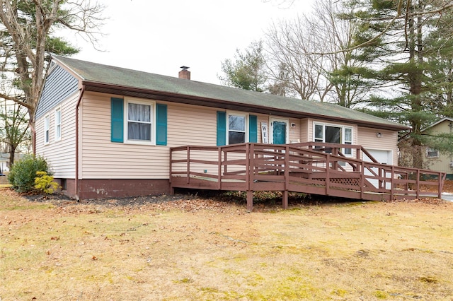 rear view of property with a wooden deck and a lawn