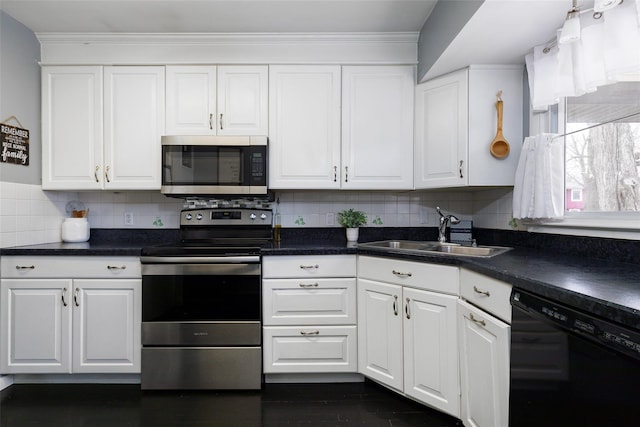 kitchen with appliances with stainless steel finishes, backsplash, white cabinetry, and sink