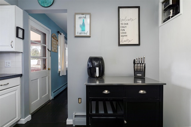 interior space with a baseboard heating unit and tasteful backsplash