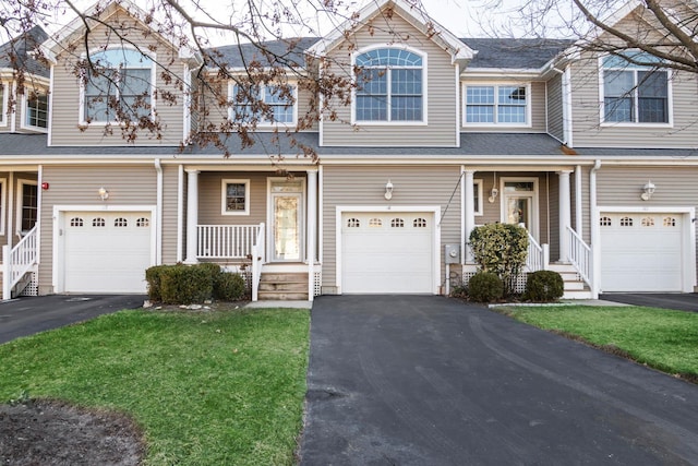 townhome / multi-family property with a front lawn and a garage