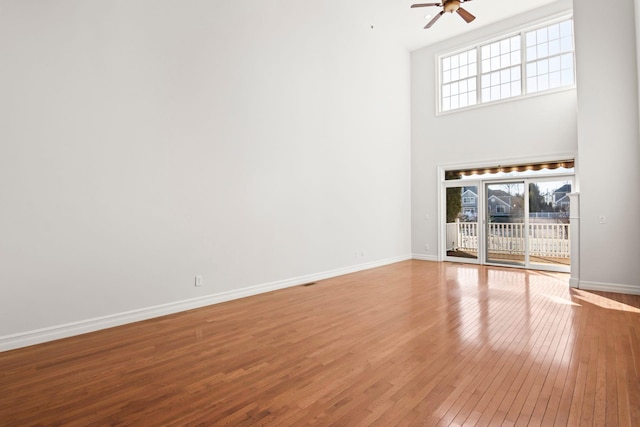 unfurnished living room featuring ceiling fan and hardwood / wood-style flooring