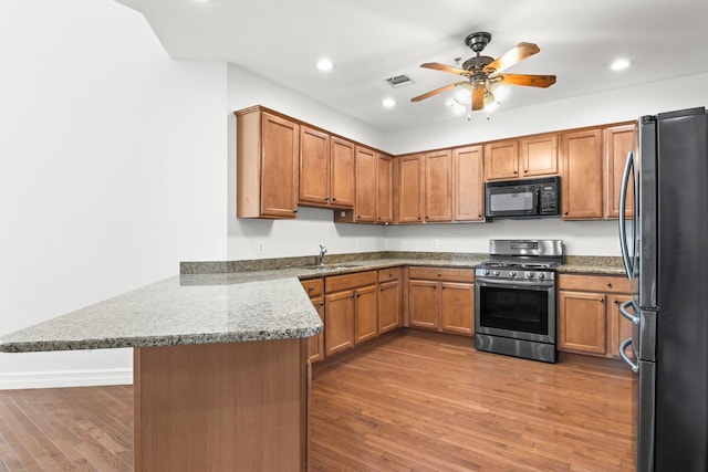 kitchen featuring kitchen peninsula, sink, stainless steel appliances, and light hardwood / wood-style flooring