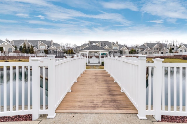 wooden deck featuring a water view and a gazebo