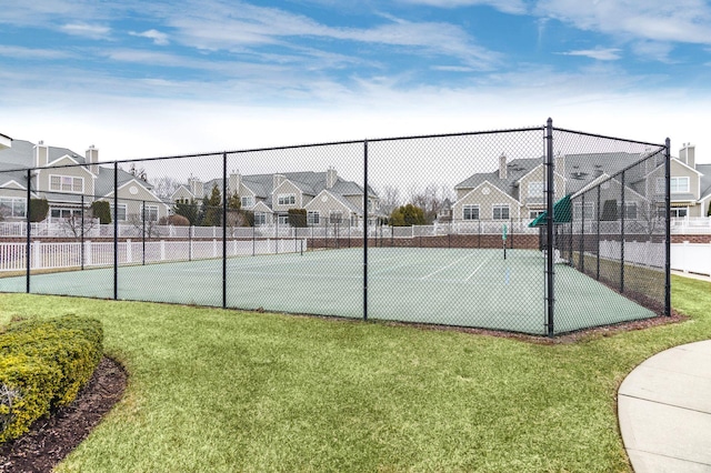 view of tennis court with a lawn