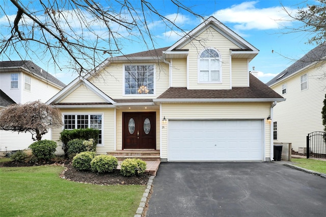 view of front of home with a garage and a front lawn