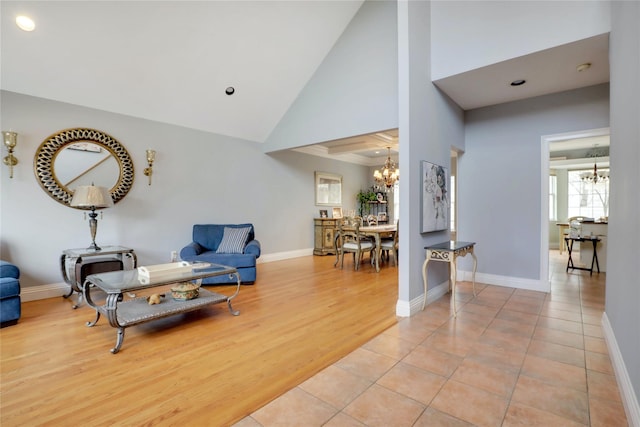 interior space with high vaulted ceiling, a notable chandelier, and light tile patterned flooring