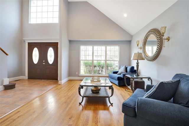 living room with high vaulted ceiling and light hardwood / wood-style flooring