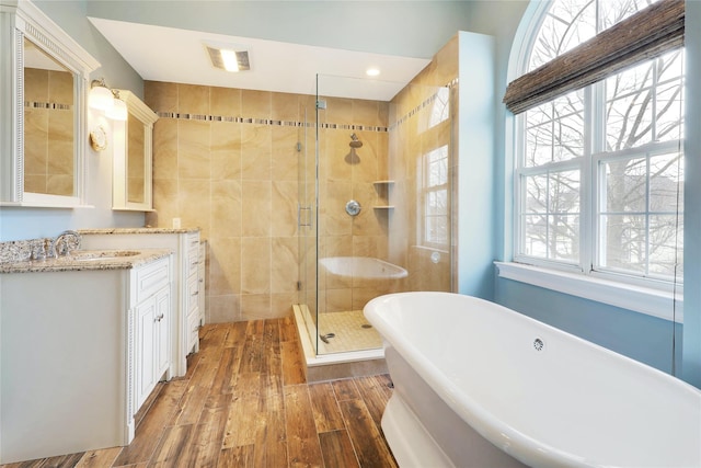 bathroom featuring vanity, independent shower and bath, and hardwood / wood-style flooring