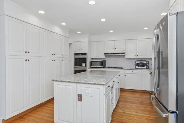 kitchen featuring appliances with stainless steel finishes, a center island, and white cabinets