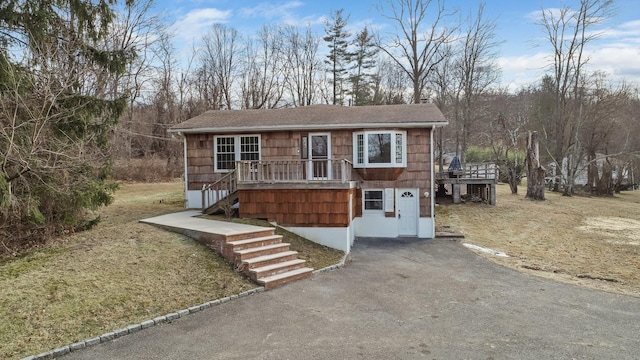 view of front of property featuring a front lawn and a deck