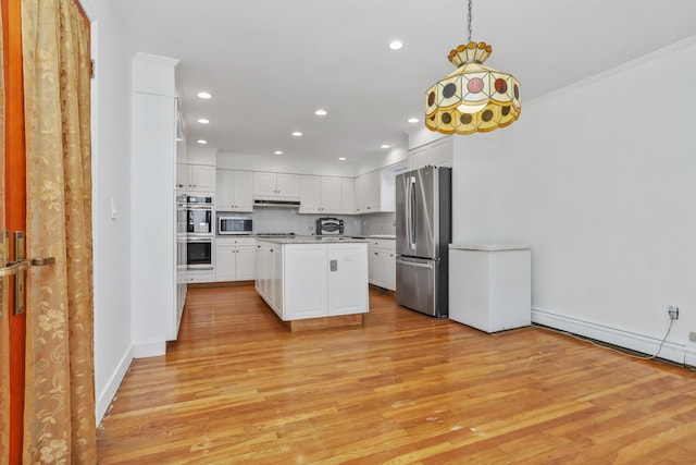 kitchen featuring light hardwood / wood-style flooring, hanging light fixtures, stainless steel appliances, white cabinets, and a kitchen island