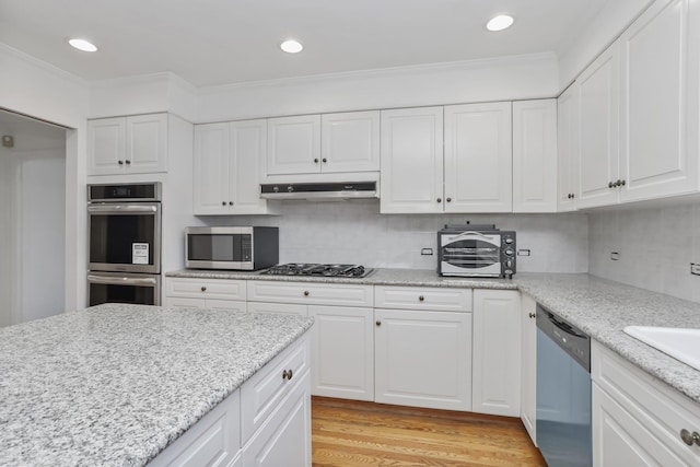 kitchen featuring white cabinetry, appliances with stainless steel finishes, and tasteful backsplash