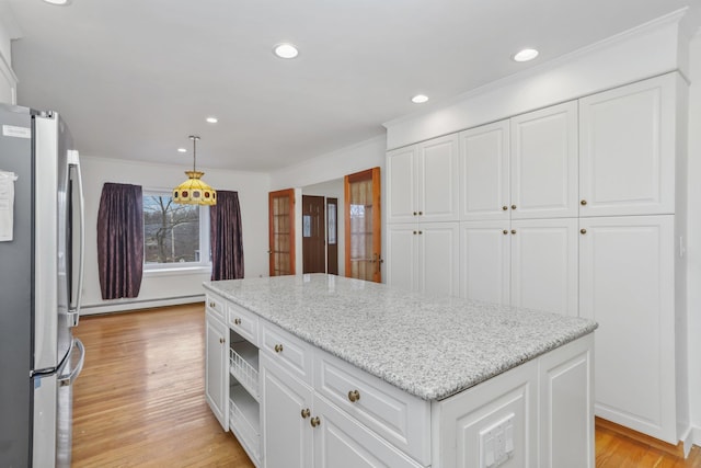 kitchen with pendant lighting, stainless steel refrigerator, baseboard heating, white cabinetry, and light stone countertops