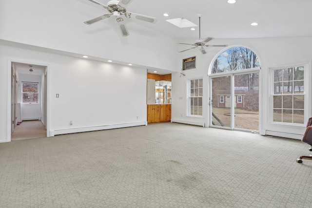 unfurnished living room featuring high vaulted ceiling, a skylight, light colored carpet, and baseboard heating