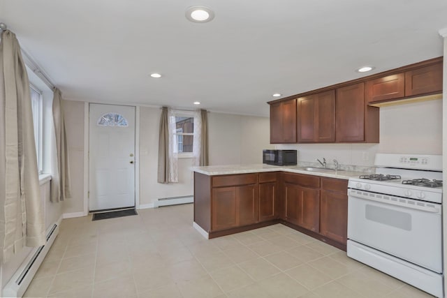 kitchen with a baseboard radiator, white gas range, sink, and kitchen peninsula