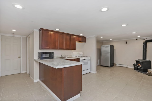 kitchen featuring stainless steel refrigerator, gas range gas stove, a baseboard heating unit, kitchen peninsula, and crown molding