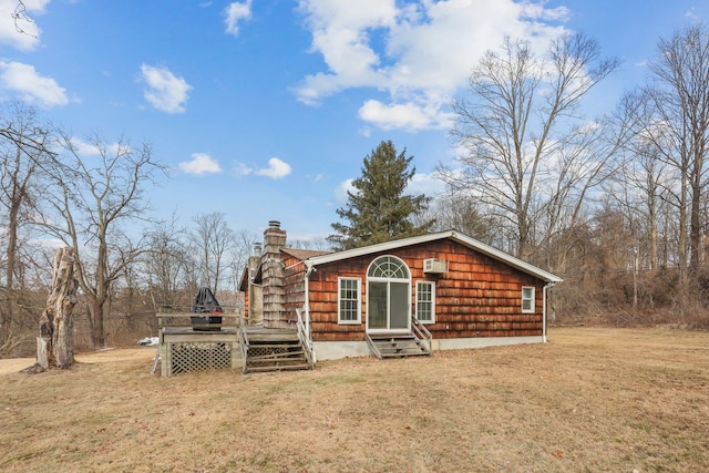 rear view of property featuring a wooden deck and a yard