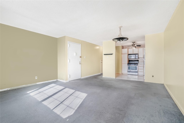 unfurnished living room with ceiling fan and carpet