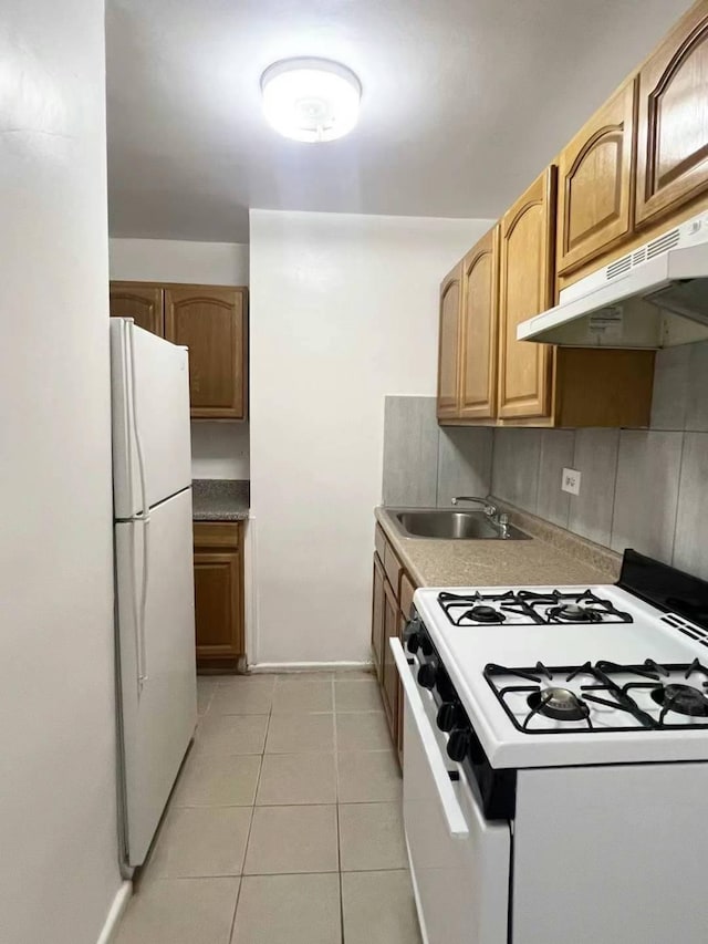 kitchen featuring sink, white appliances, light tile patterned floors, and tasteful backsplash