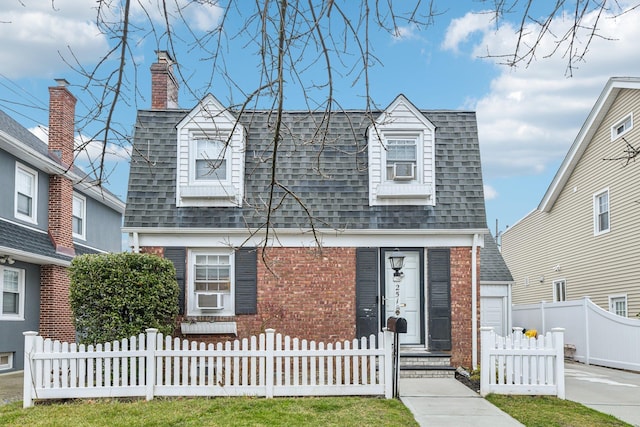 cape cod-style house featuring cooling unit and a garage