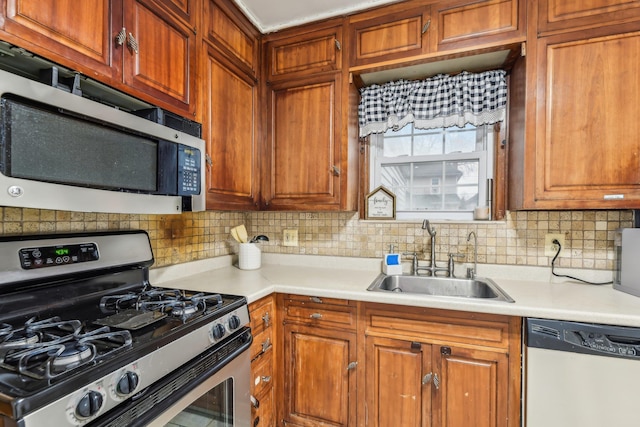 kitchen featuring dishwasher, backsplash, stainless steel gas range oven, and sink