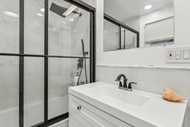 bathroom with shower / bath combination with glass door and vanity