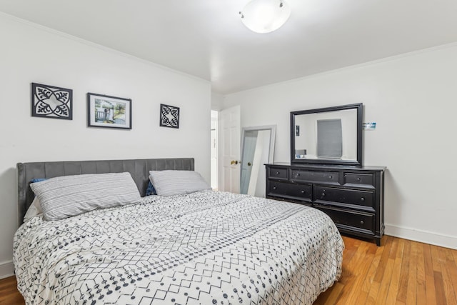 bedroom with wood-type flooring and crown molding