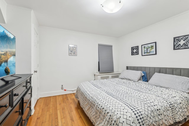 bedroom featuring ornamental molding and light hardwood / wood-style floors