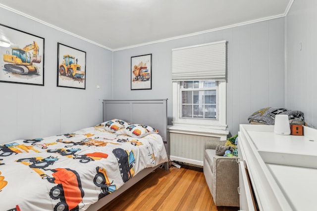 bedroom featuring radiator, light wood-type flooring, and crown molding