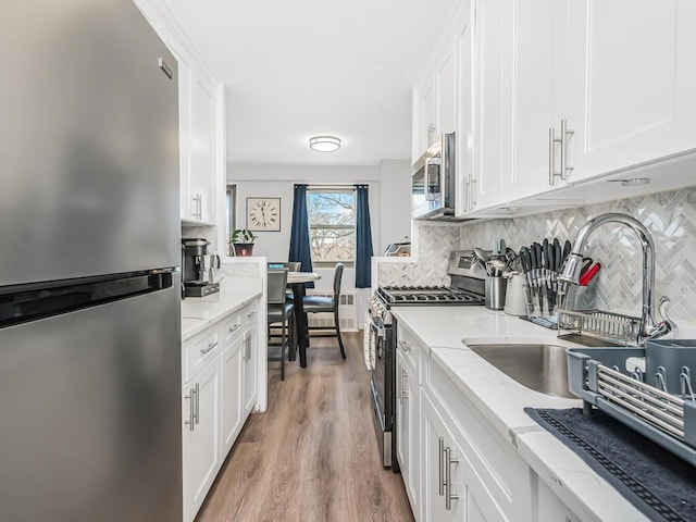 kitchen featuring white cabinetry, stainless steel appliances, and tasteful backsplash