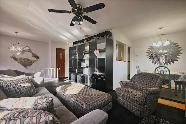 living room with ceiling fan with notable chandelier and hardwood / wood-style floors