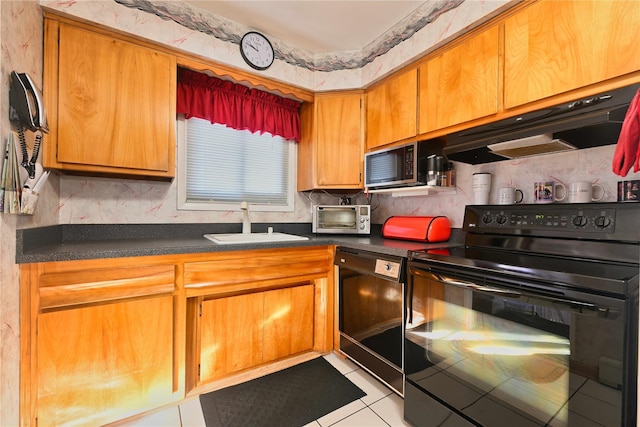 kitchen featuring sink, light tile patterned floors, black appliances, and tasteful backsplash