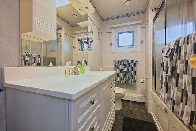 full bathroom featuring tile walls, toilet, vanity, and tile patterned flooring