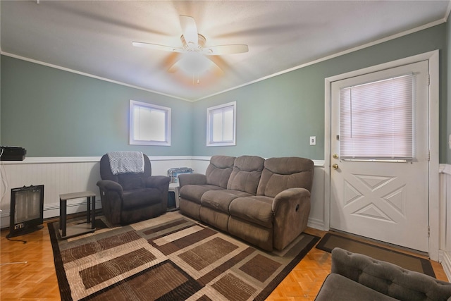 living room with ceiling fan, a baseboard heating unit, parquet floors, and ornamental molding