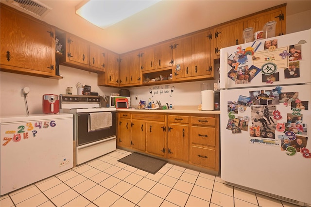 kitchen with light tile patterned flooring and white appliances