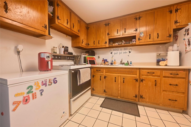 kitchen with light tile patterned floors, white electric range, fridge, and sink