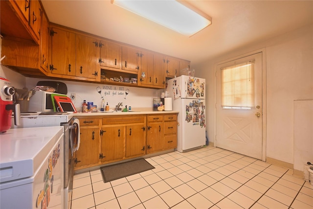 kitchen featuring sink, light tile patterned floors, and white fridge