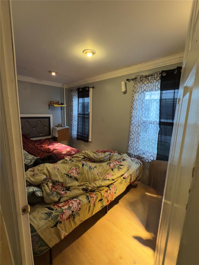 bedroom featuring crown molding and hardwood / wood-style flooring