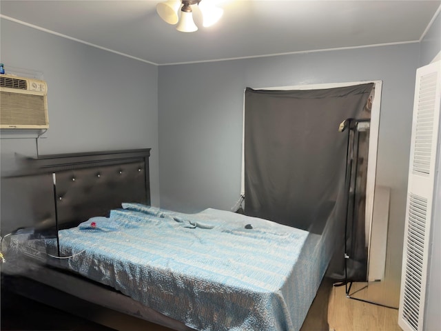 bedroom with a wall unit AC and light hardwood / wood-style flooring