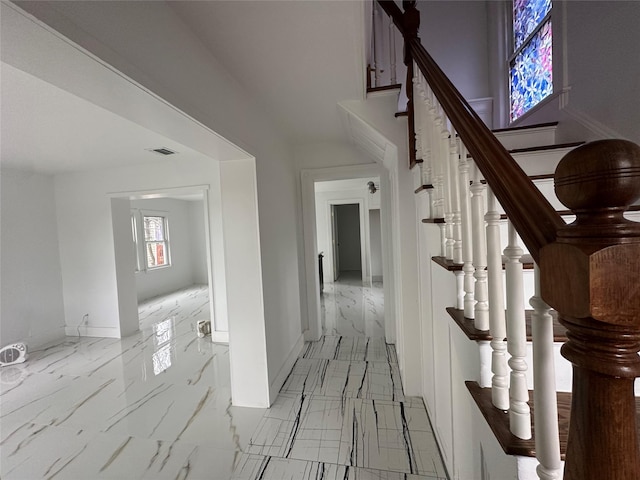 interior space with marble finish floor, stairway, visible vents, and baseboards