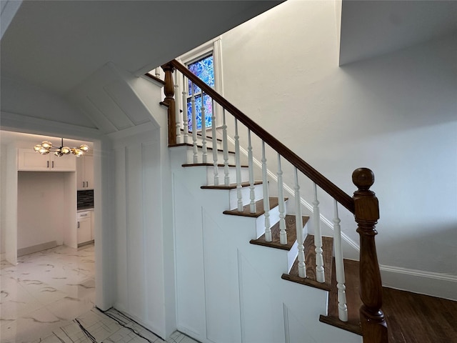 staircase with marble finish floor and baseboards